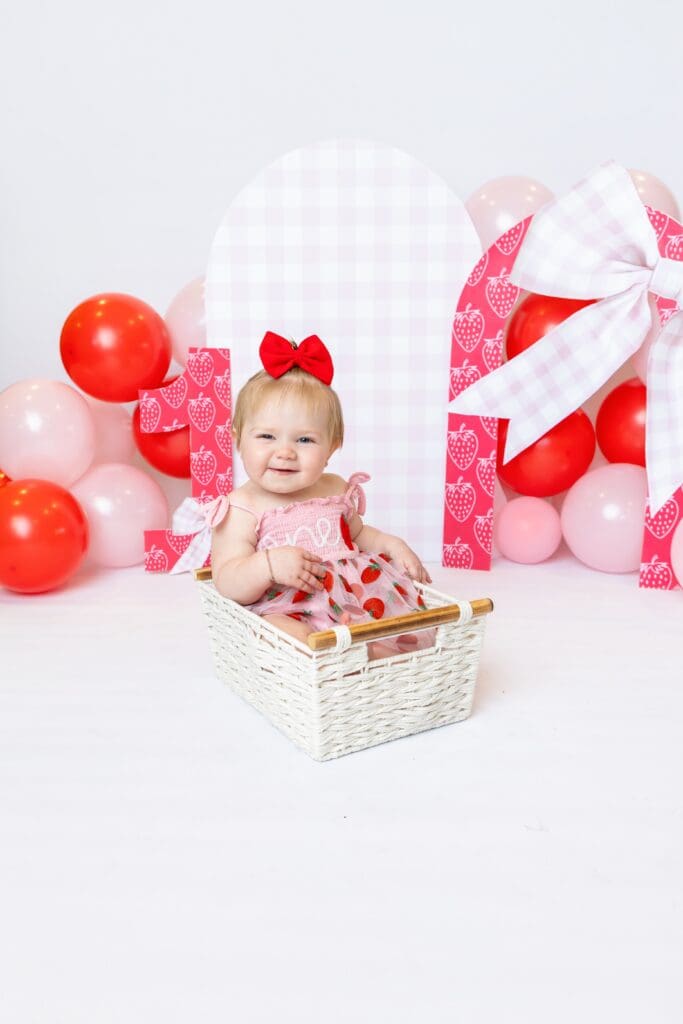 Creative first birthday photography featuring a custom backdrop and decorations