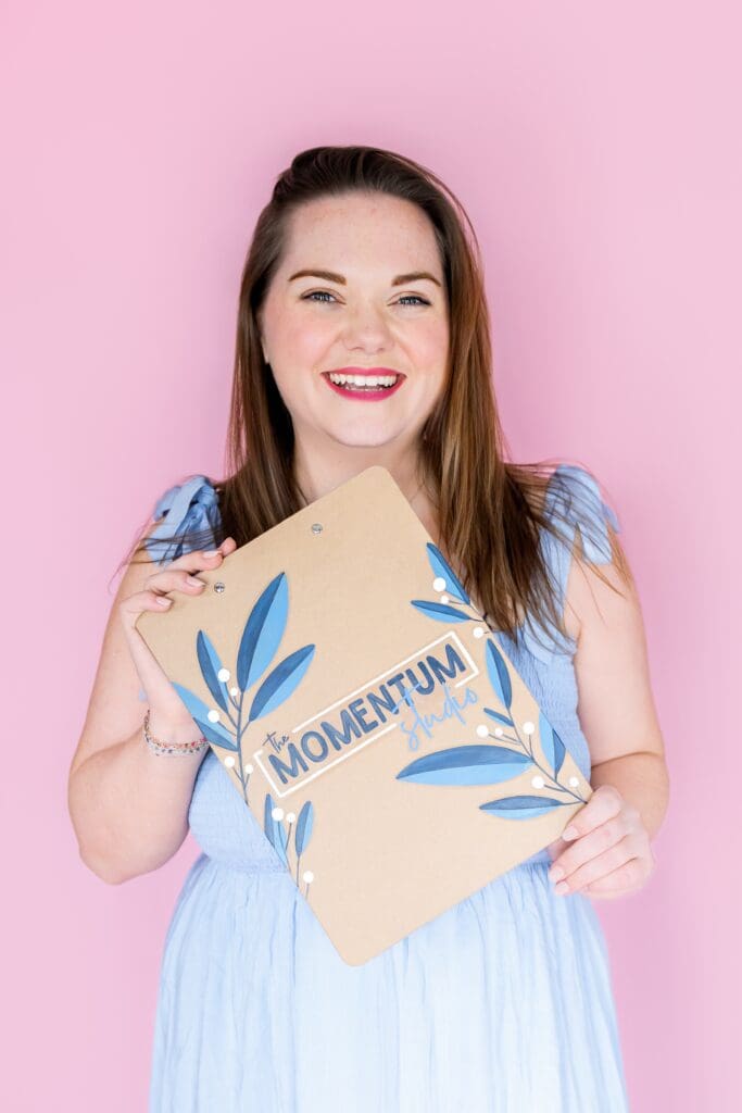 Brand photography session showing entrepreneur smiling with logo clipboard in Pittsburg KS