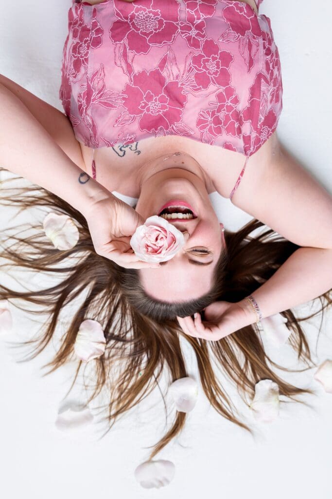 Business coach laughing surround by flowers during brand photoshoot in pittsburg ks
