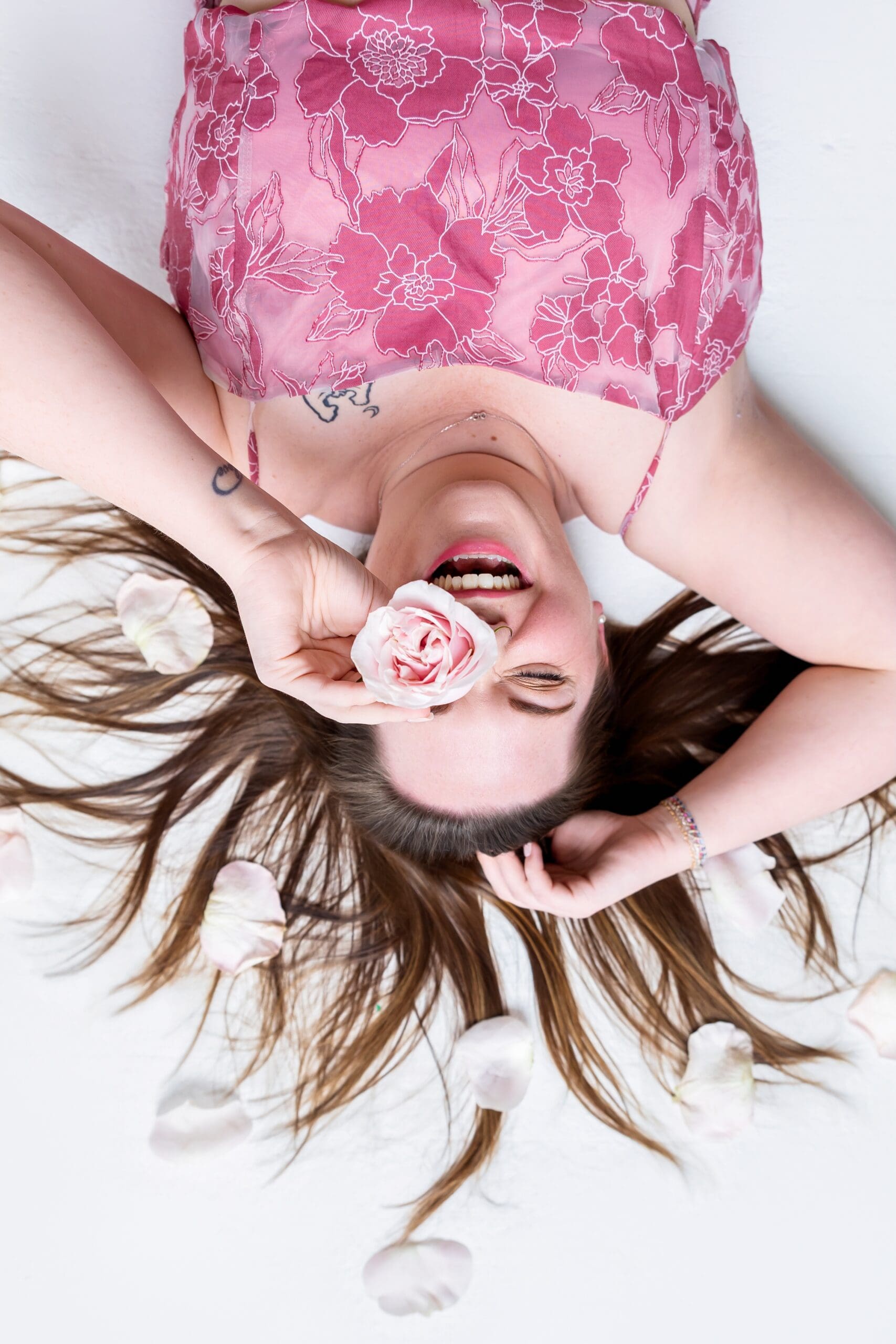 Business coach laughing surround by flowers during brand photoshoot in pittsburg ks